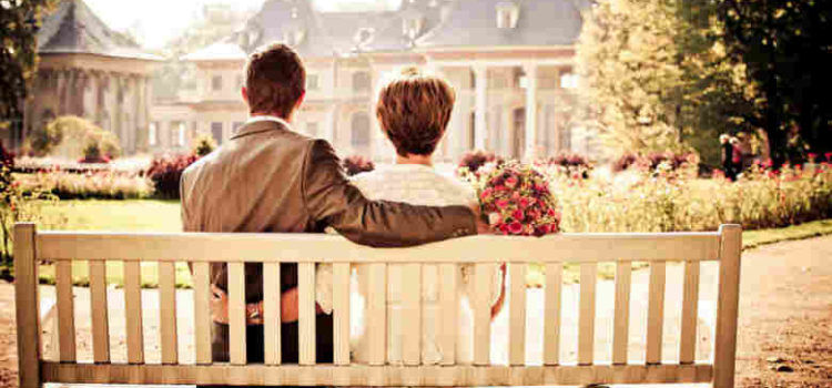 couple on park bench arms around each other