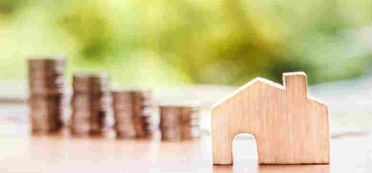 wooden house beside stacks of coins